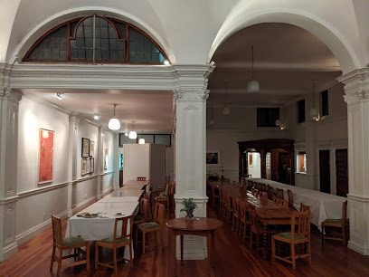Historic dining hall interior with long wooden tables and arches