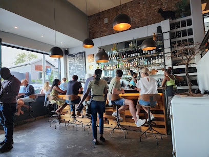 Bar at Black Sheep Restaurant with seated diners and bartender under pendant lights