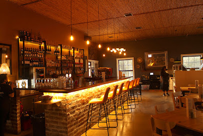 Massimo's interior with illuminated brick bar, high stools and hanging bulbs