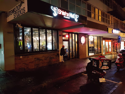 Khayelitsha street at night outside Shisha Hut with pizza delivery scooter