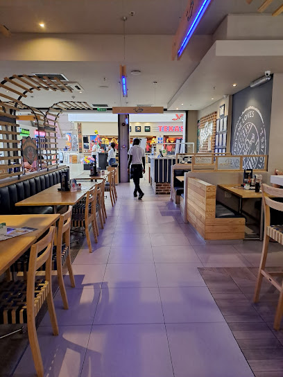 John Dory’s N1 City dining area with wooden tables and central aisle
