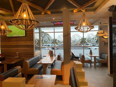 California Spur Halaal dining area with booths and hanging chandeliers