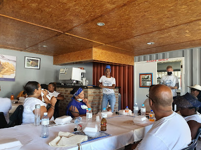 Guests seated at long table listening to server at Eziko Restaurant