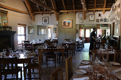 96 Winery Road dining room with wooden tables, place settings and wine glasses