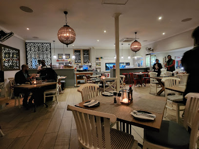 Sabrias Restaurant interior — softly lit dining room with wooden tables and pendant lanterns