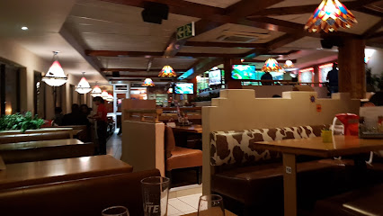 Golden River Spur interior with cow-print booths, stained-glass pendant lights and TVs