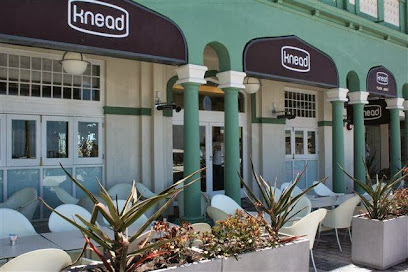 Knead Bakery Muizenberg exterior with brown awnings and outdoor seating