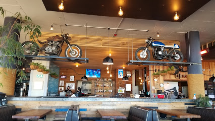 Jerry's Burger Bar Blouberg interior with two vintage motorcycles above the bar