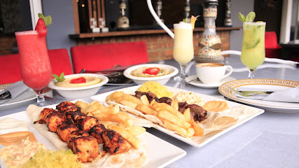 Aladdin On Loop table with grilled kebabs, fries, curries and colorful drinks