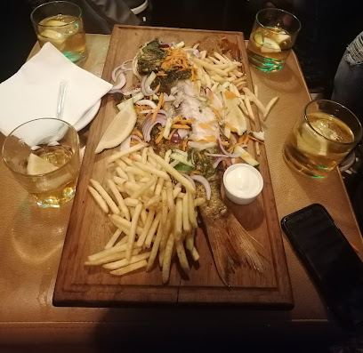 Mofire African Cuisine wooden platter with whole fish, fries, sliced onions, lemon wedge, dipping sauce
