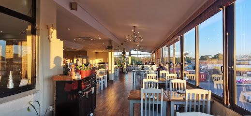 Yo Eastern Fusion dining room with white chairs and sunset window views