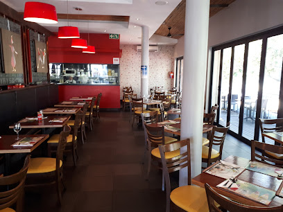 Simply Asia Durbanville dining room with set tables, red pendant lamps, and patio seating