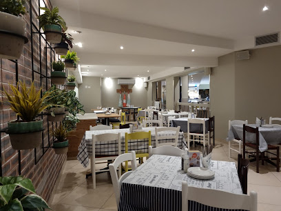 Ocean Basket Bloubergstrand relaxed indoor dining area with tables and plants