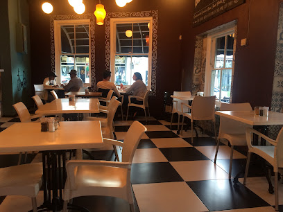 Cocoa Cha Chi cafe interior with checkered floor, white tables and seated customers