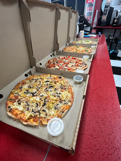 La Inferno's Pizzeria Plattekloof — several open pizzas in boxes on red counter