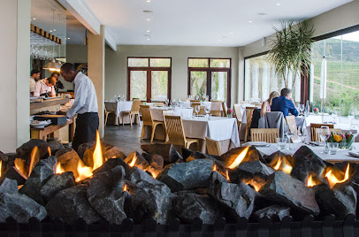 The Jordan Restaurant dining room with server, stone fireplace and vineyard views