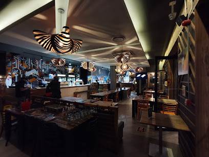 RocoMamas Rondebosch interior with lit pendant lamps and dining tables