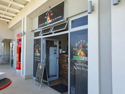 Matt's Pizzas storefront with open door, window logo and chalkboard menu