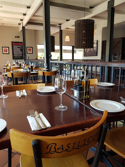 Basilico dining room with set wooden tables, plates and wine glasses