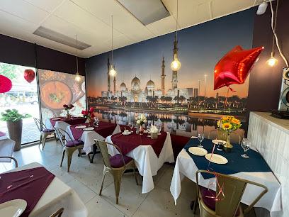 Royal Restaurant Indian dining room with mosque mural and set tables
