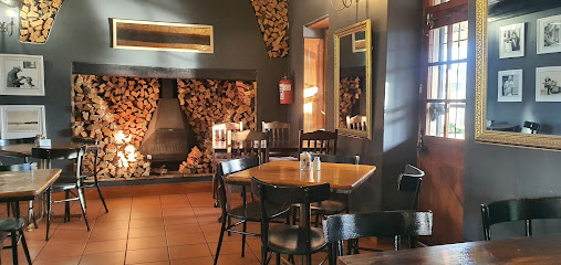 Cafe 22 on Oxford interior with fireplace, stacked firewood, and wooden tables