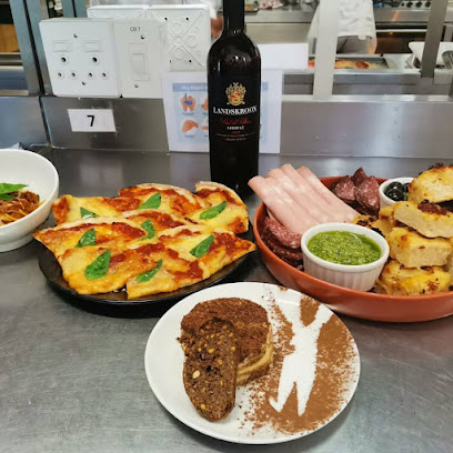 Nandi Chop Kitchen flame-grilled meat platter with sides and wine