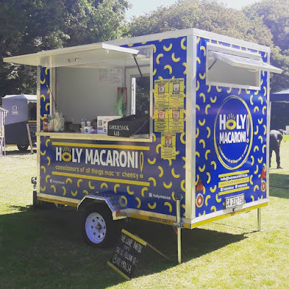 Holy Macaroni blue food trailer serving macaroni at outdoor event