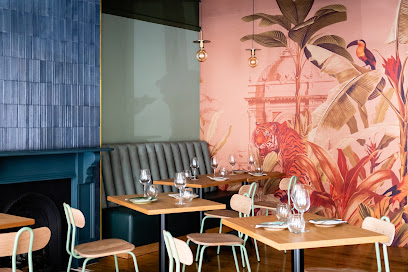Vadivelu dining area with set tables, banquette seating and tropical mural
