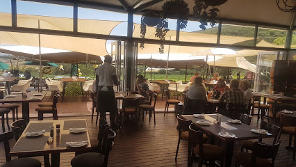 Interior dining area at Hillcrest Restaurant opening to shaded terrace and lawn views