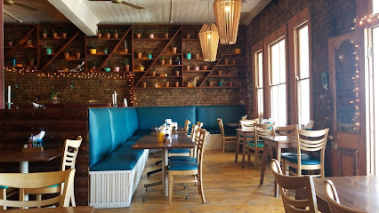 El Burro Greenpoint dining area with teal banquette seating, wooden tables and hanging pendant lights
