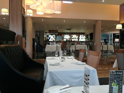 Cattle Baron Pinelands dining room with white-clothed tables and bar