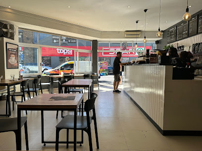 Mischu Coffee interior, counter with barista and customer, seating by front window