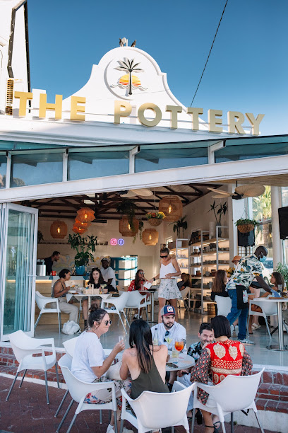 The Pottery Camps Bay café with outdoor diners beneath yellow 'THE POTTERY' sign
