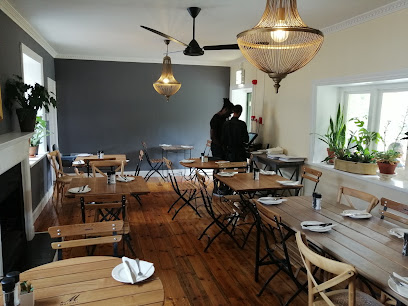Quince Restaurant & Deli indoor dining room with wooden tables and pendant lights
