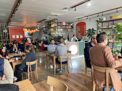 Spoon Bakery & Eatery interior, cozy café with customers at wooden tables and counter