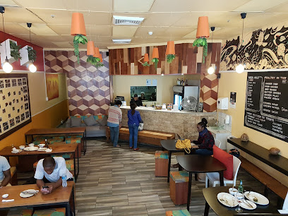 Meeting Point Tanzanian restaurant interior with counter, menu board, and diners