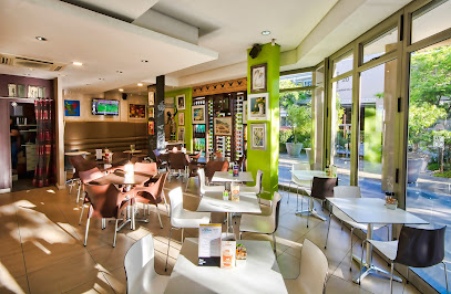 Cafe Nood interior: modern tables and chairs by sunlit floor-to-ceiling windows