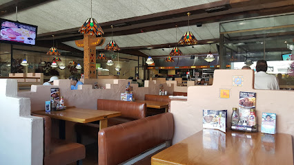 Tomahawk Spur Halaal interior with brown booths and stained-glass lamps