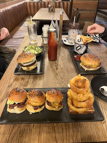 Hudsons Kloof burgers with onion rings, fries and milkshake on table