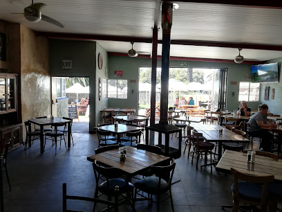 The Olive Bistro interior with wooden tables and open doors to patio seating