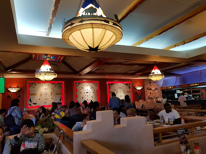 Texas Spur Goodwood dining room with diners at wooden booths under chandeliers