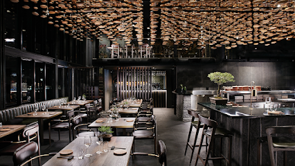Fyn Restaurant chic dining room with wooden tables, bar and sculptural ceiling