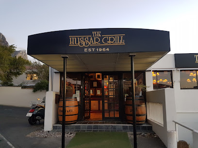 The Hussar Grill Camps Bay entrance with awning and wooden barrels