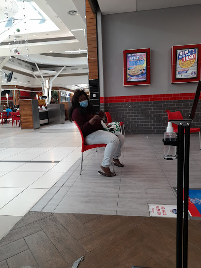 Masked customer seated in Roman's Pizza Promenade food court