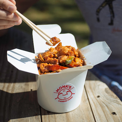 Monk's Chinese takeout box of stir-fry being eaten with chopsticks