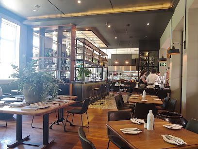 Blockhouse Kitchen dining room with set tables, plants and staff