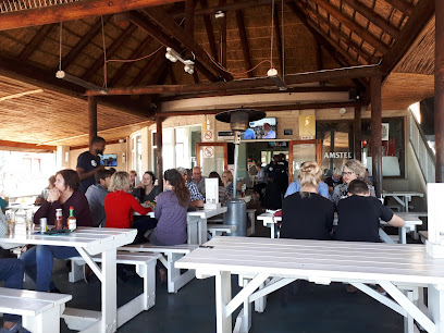Guests dining at Seafood Lapa Melkbosstrand under rustic thatched roof