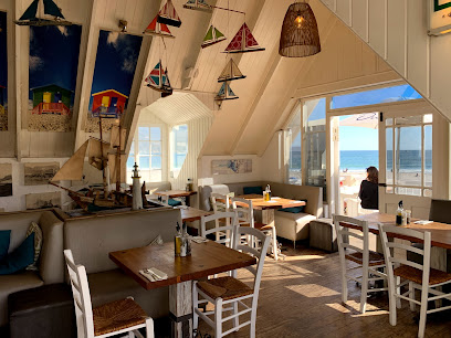 Dunes Beach Restaurant & Bar dining room with wooden tables, nautical decor and ocean view