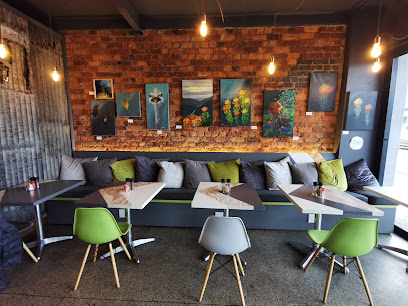 Peak Cafe Tokai cozy bench seating with tables, green chairs and hanging pendant lights