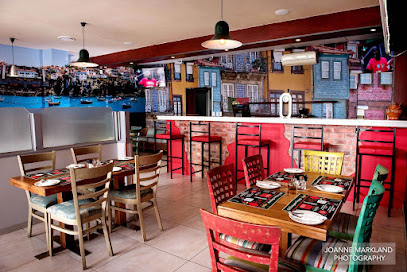 Gallo Portuguese Restaurant Milnerton interior with colorful mural, bar stools and tables set for dining